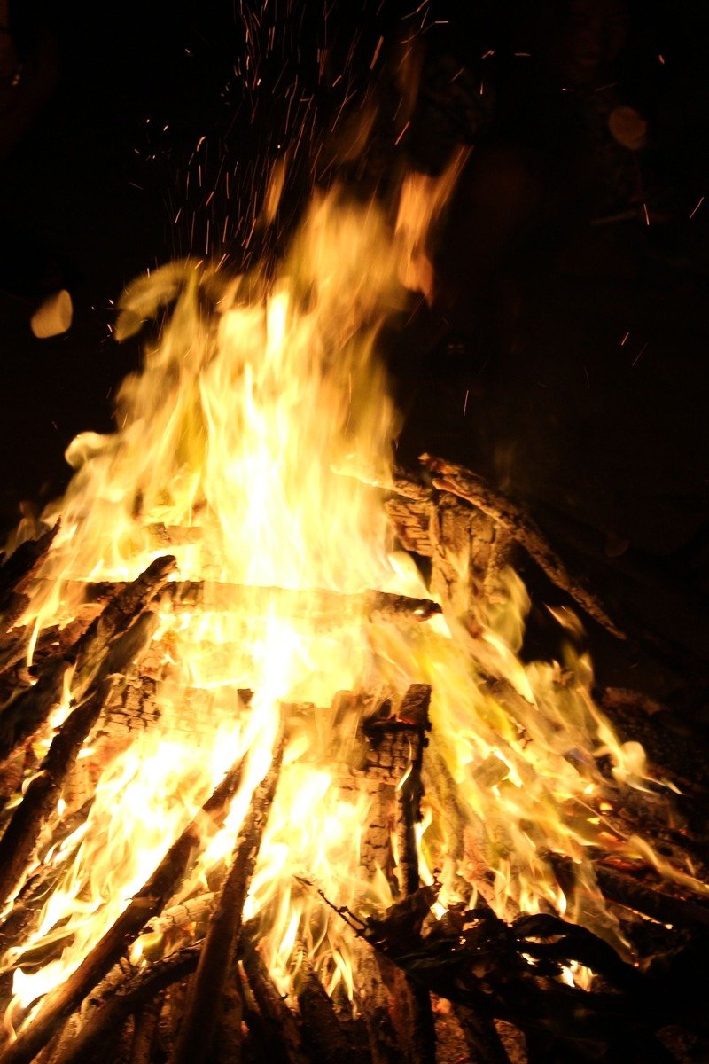 Toasted marshmallows over campfire with perfume bottle nearby