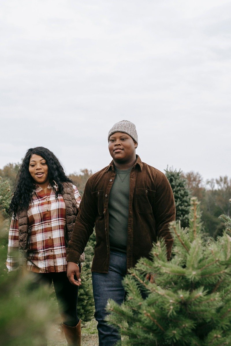 Couple in denim and red flannel outfits for a rustic Christmas photo