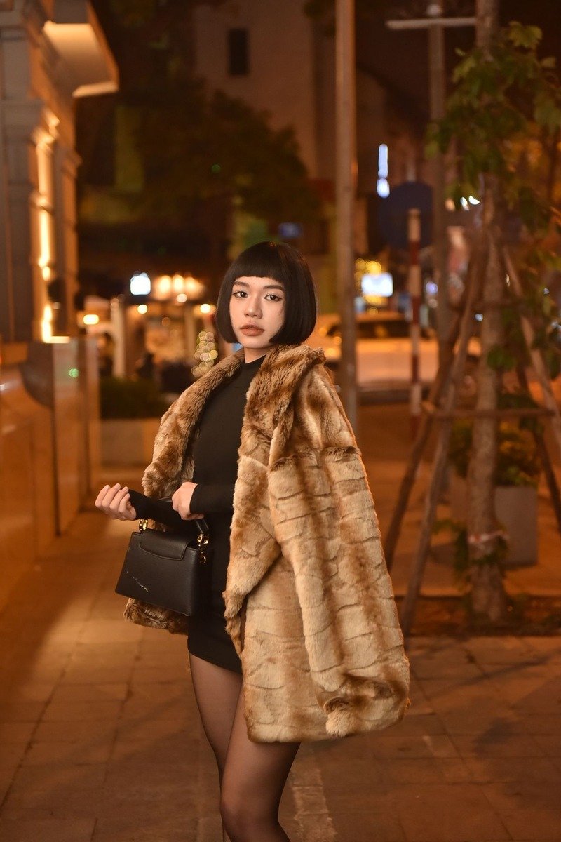 Woman in a faux fur coat over an evening outfit