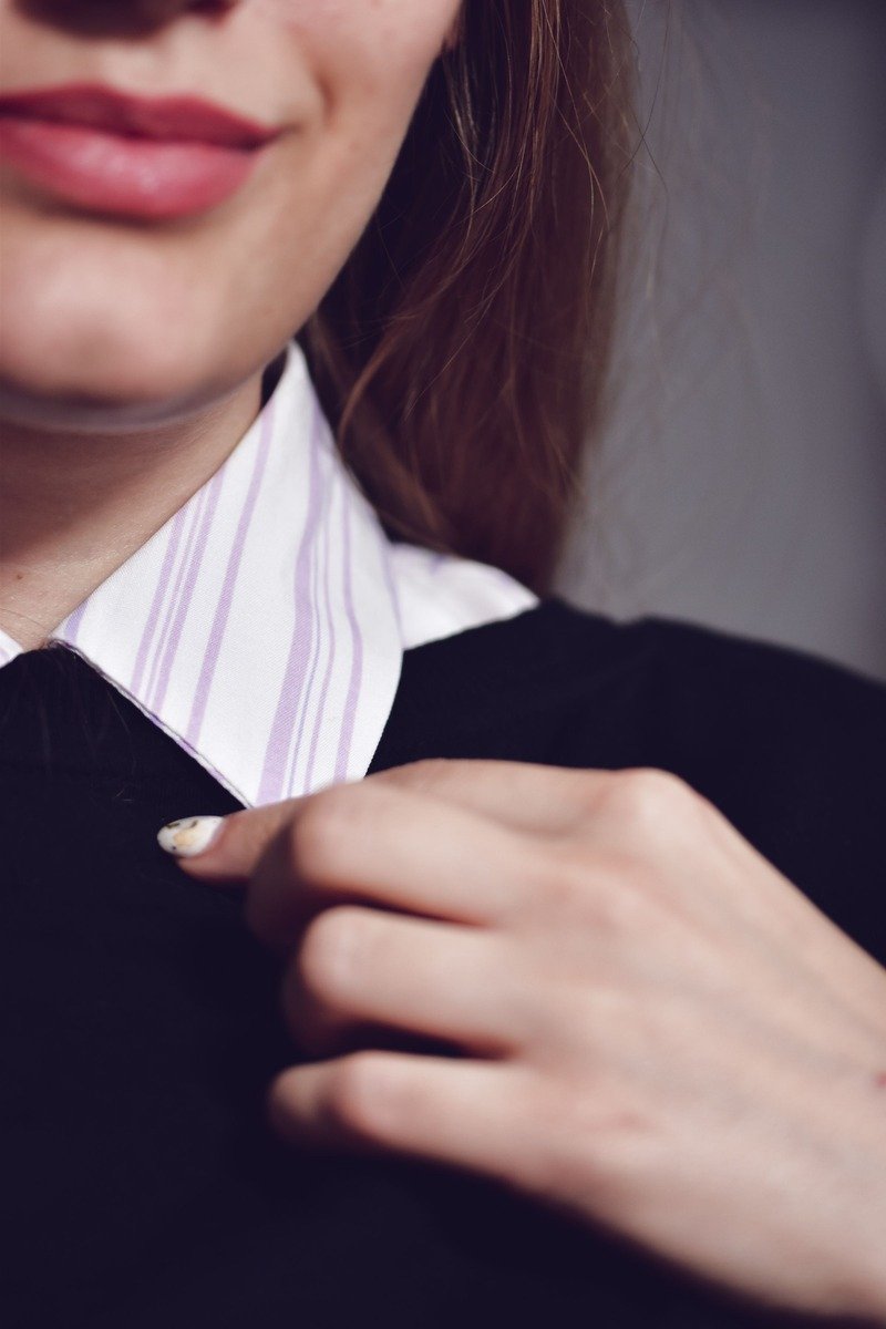 Woman in an oversized sweater over a white button down shirt