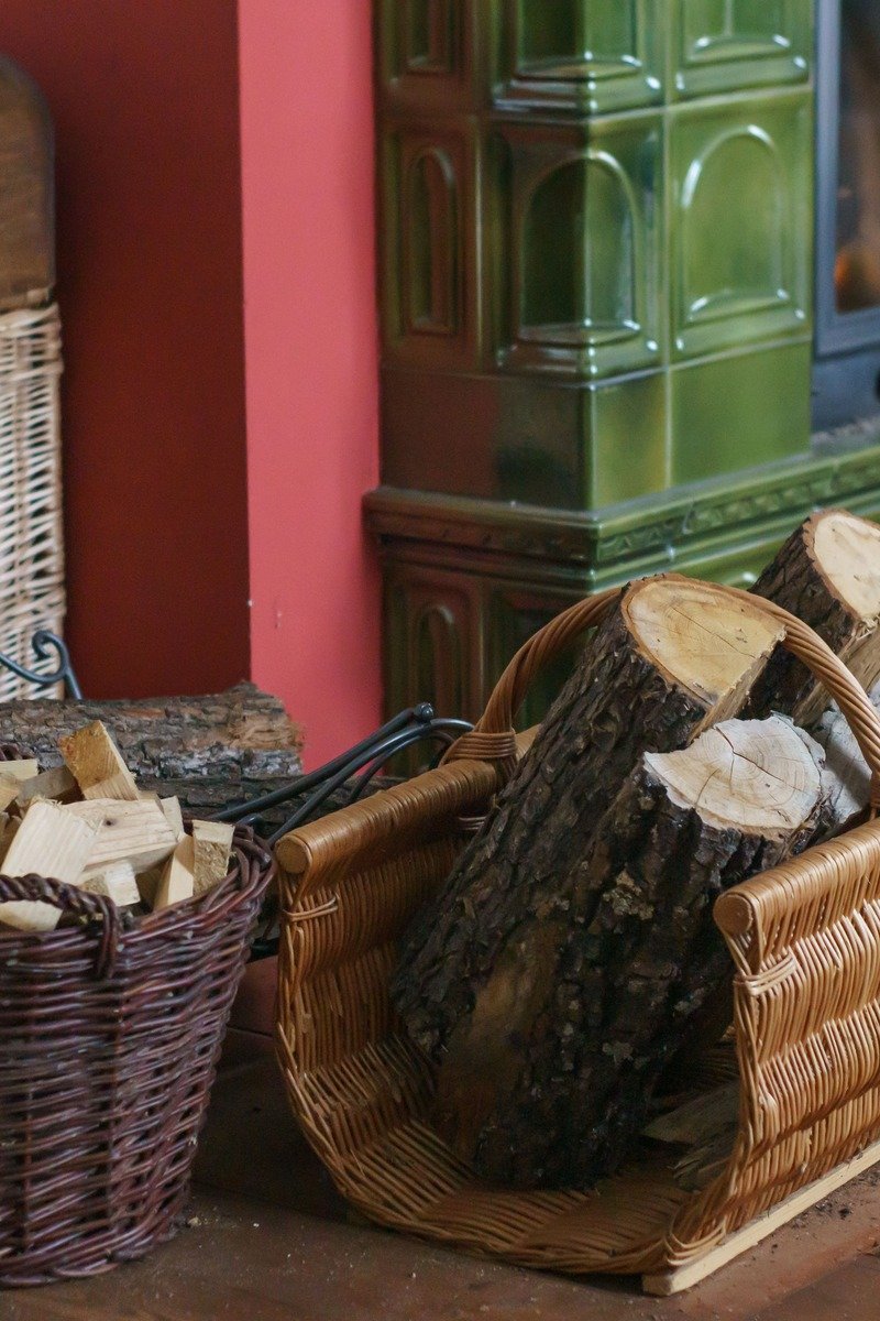 Basket of firewood logs beside a fireplace