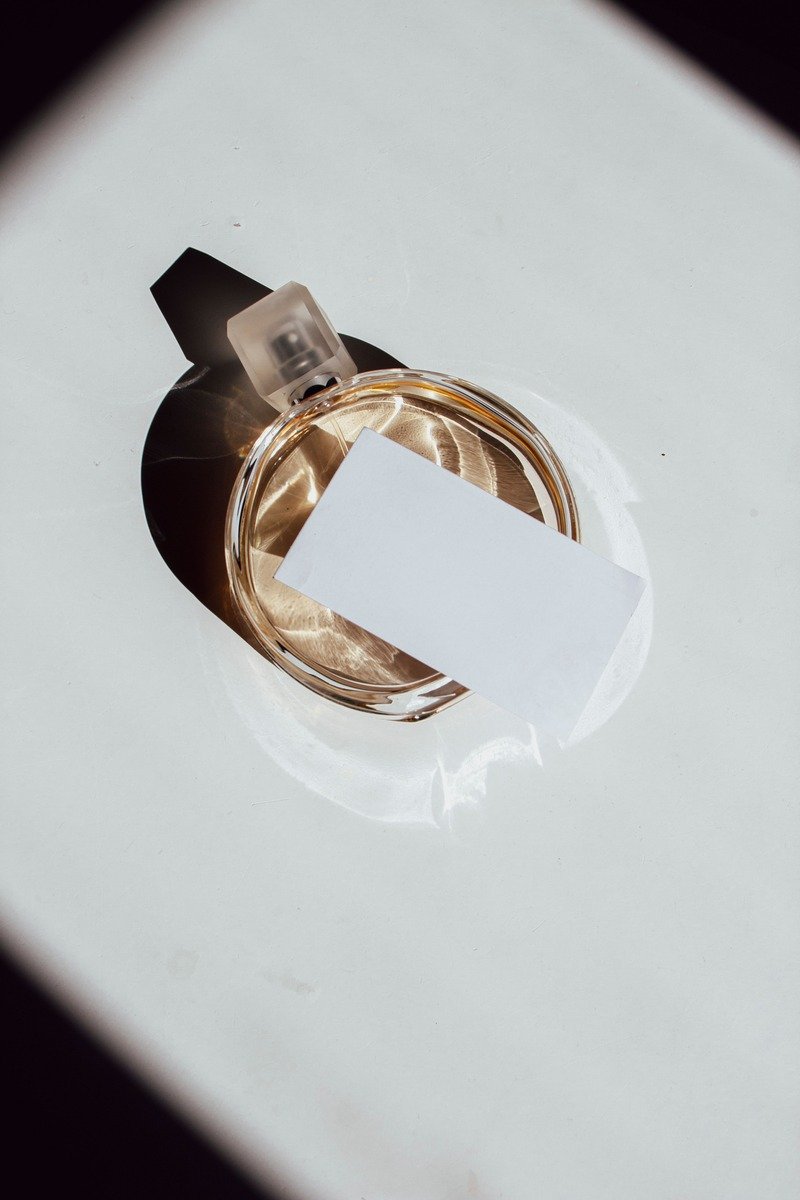Minimalist perfume bottle on clean white silk fabric