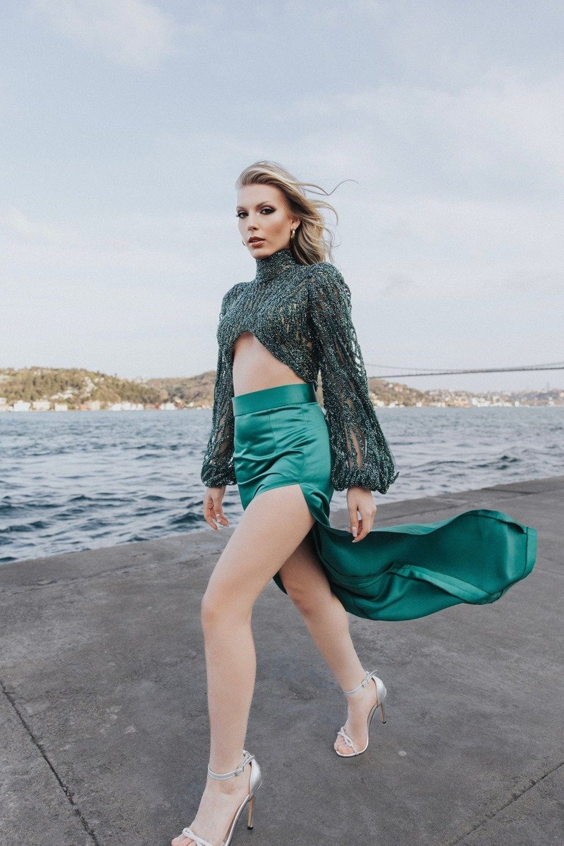Woman in a green satin skirt and dark top