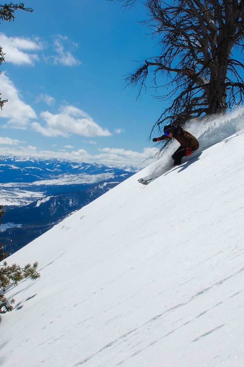 Skiers on snowy Utah slopes with red rock country in the distance