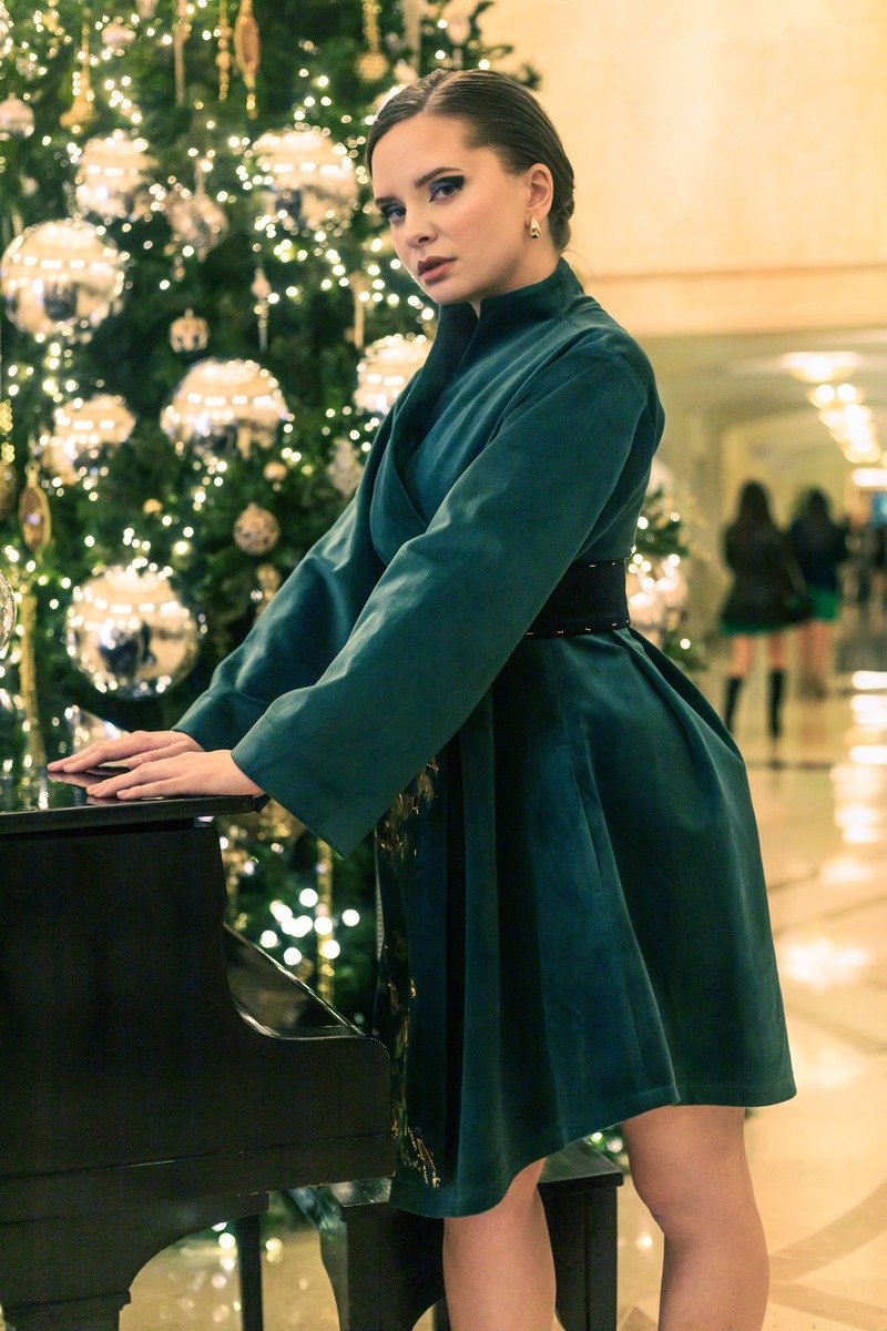 Woman in an emerald velvet wrap dress for a Christmas portrait