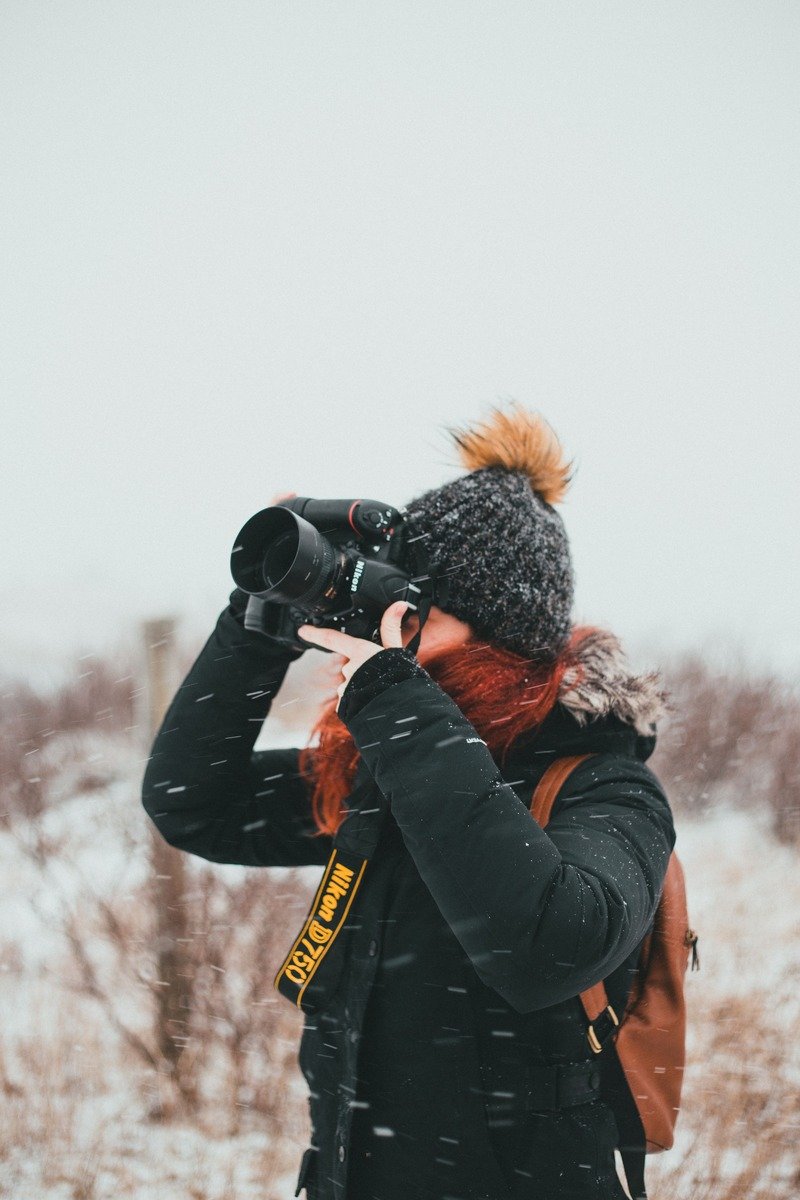 Person taking winter photographs outdoors