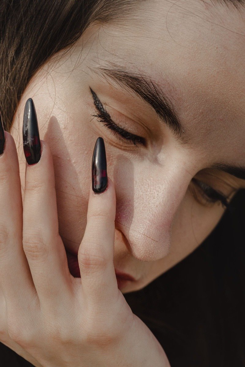 Black stiletto nails with subtle red shimmer