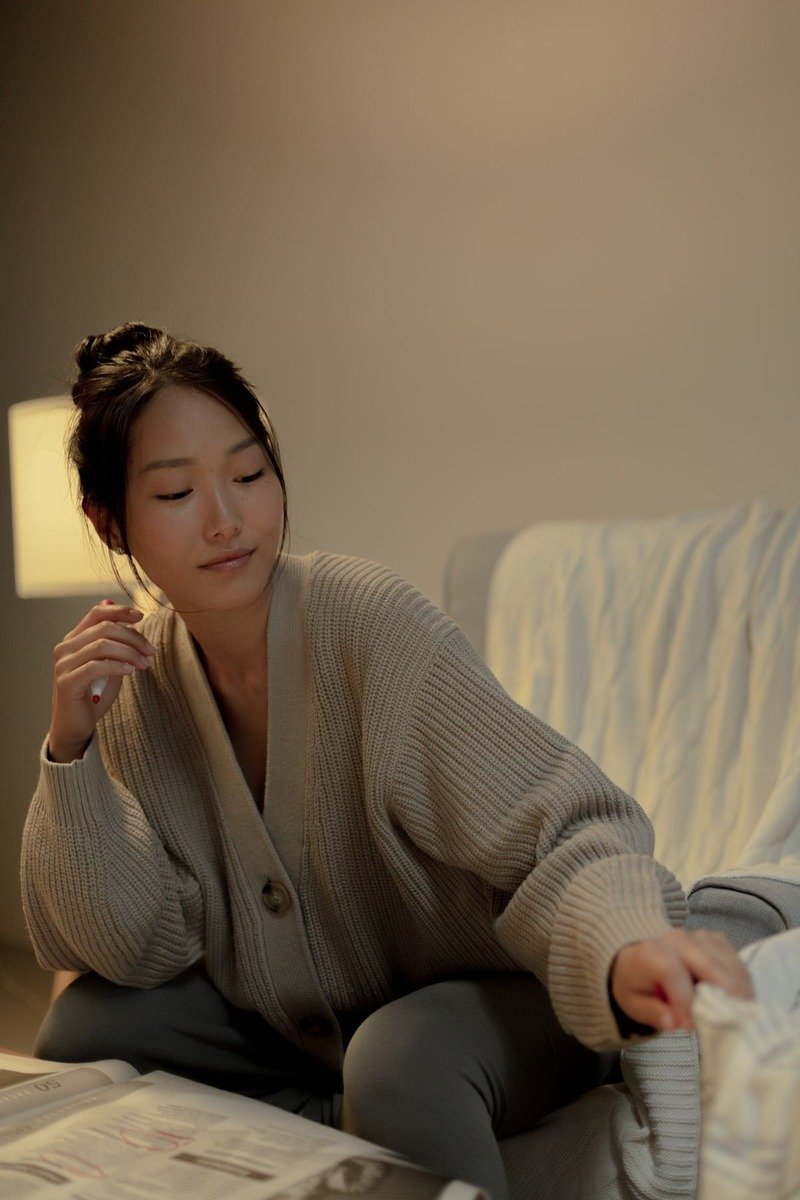 Woman in an oversized cardigan and joggers at home