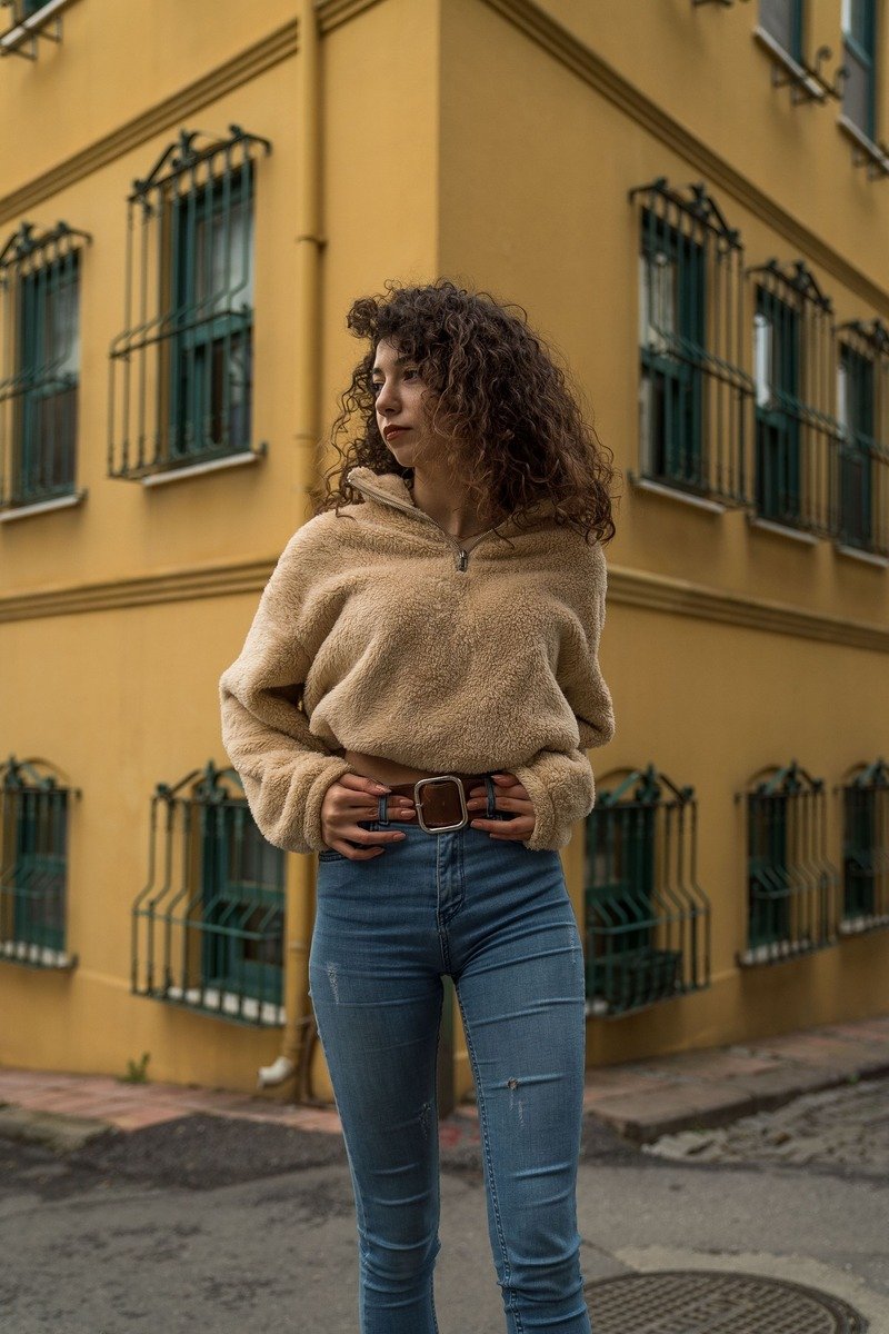 Woman in a belted oversized sweater with jeans