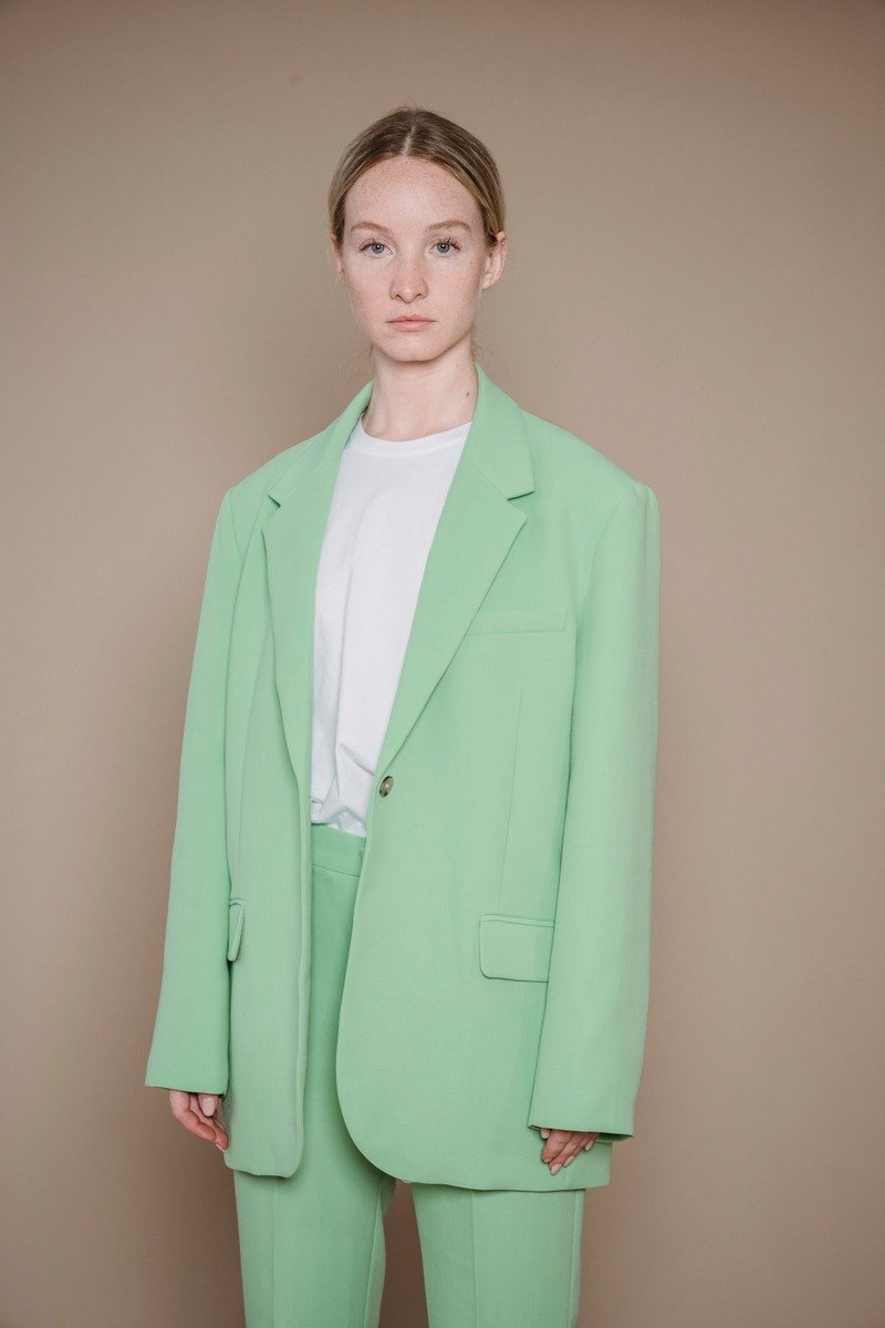Woman in a green tailored suit outfit