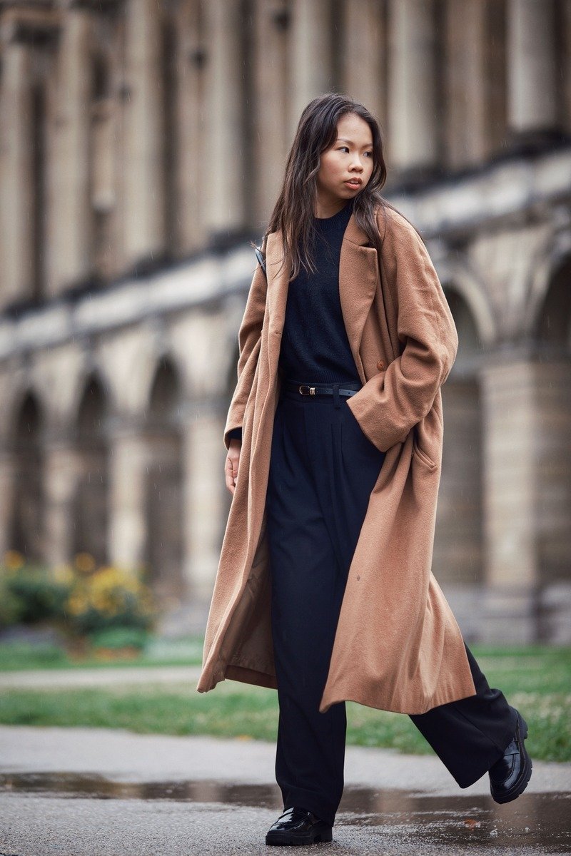 Woman in a midi dress with a long coat walking to the office