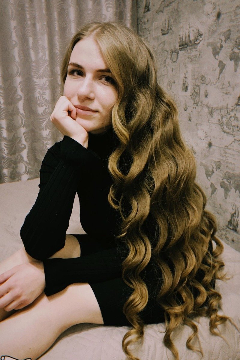 Curtain bangs with mocha balayage framing the face on wavy hair