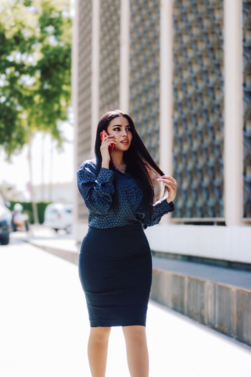 Woman in a pencil skirt and silk blouse at a conference table