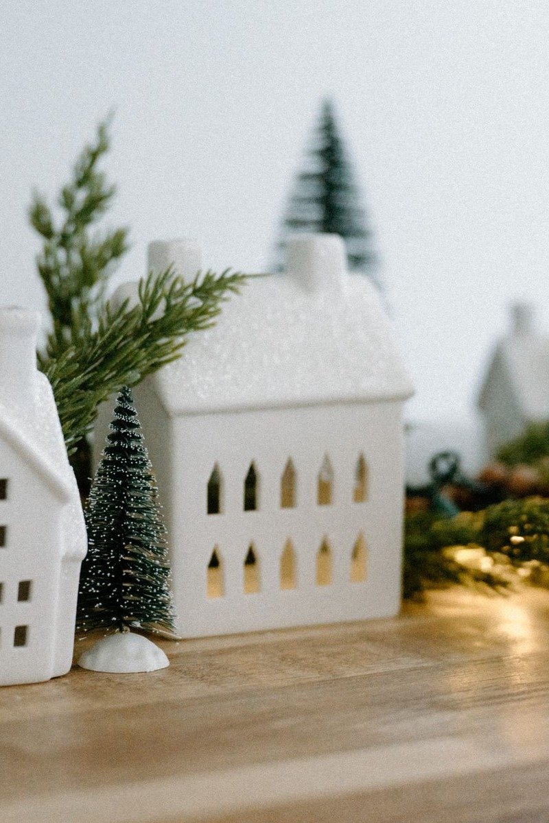 All white ceramic Christmas village display with warm lights