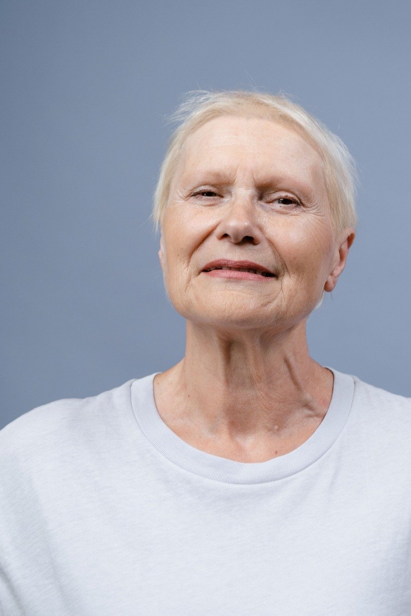 Woman over 50 with a short white pixie haircut