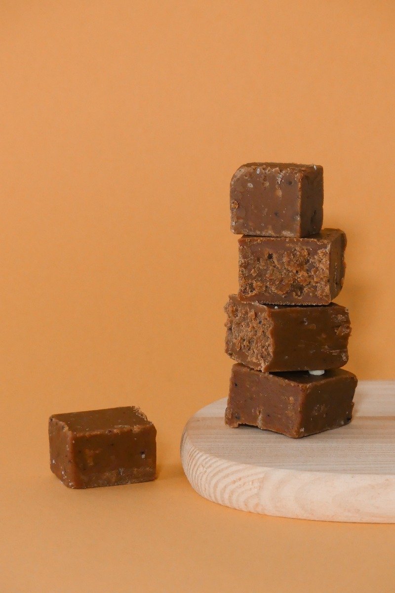 Chocolate fudge squares stacked on a wooden board