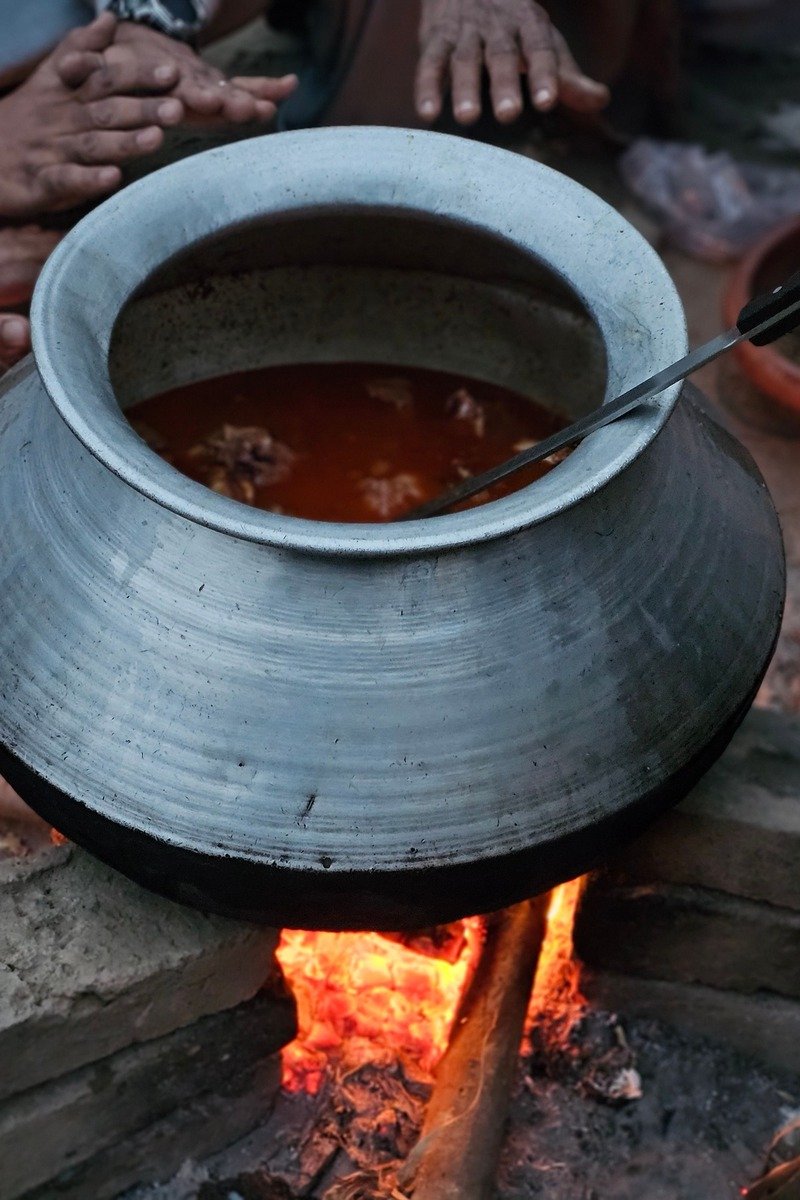 Cooking a large pot of stew over an outdoor fire