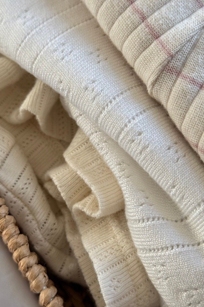 Basket of blankets beside a sofa