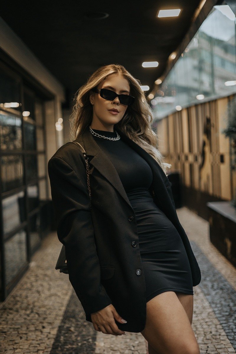 Woman in a knit dress with a belted blazer at work