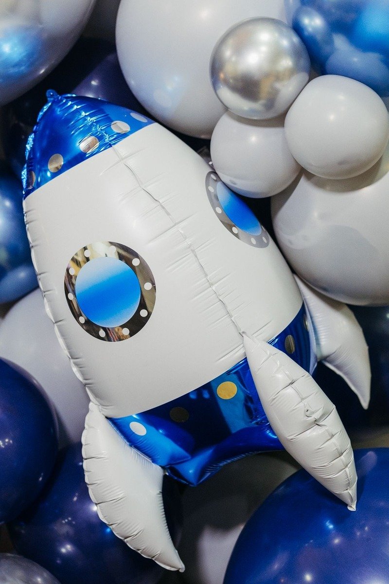 Space themed birthday party with rocket decorations and star balloons
