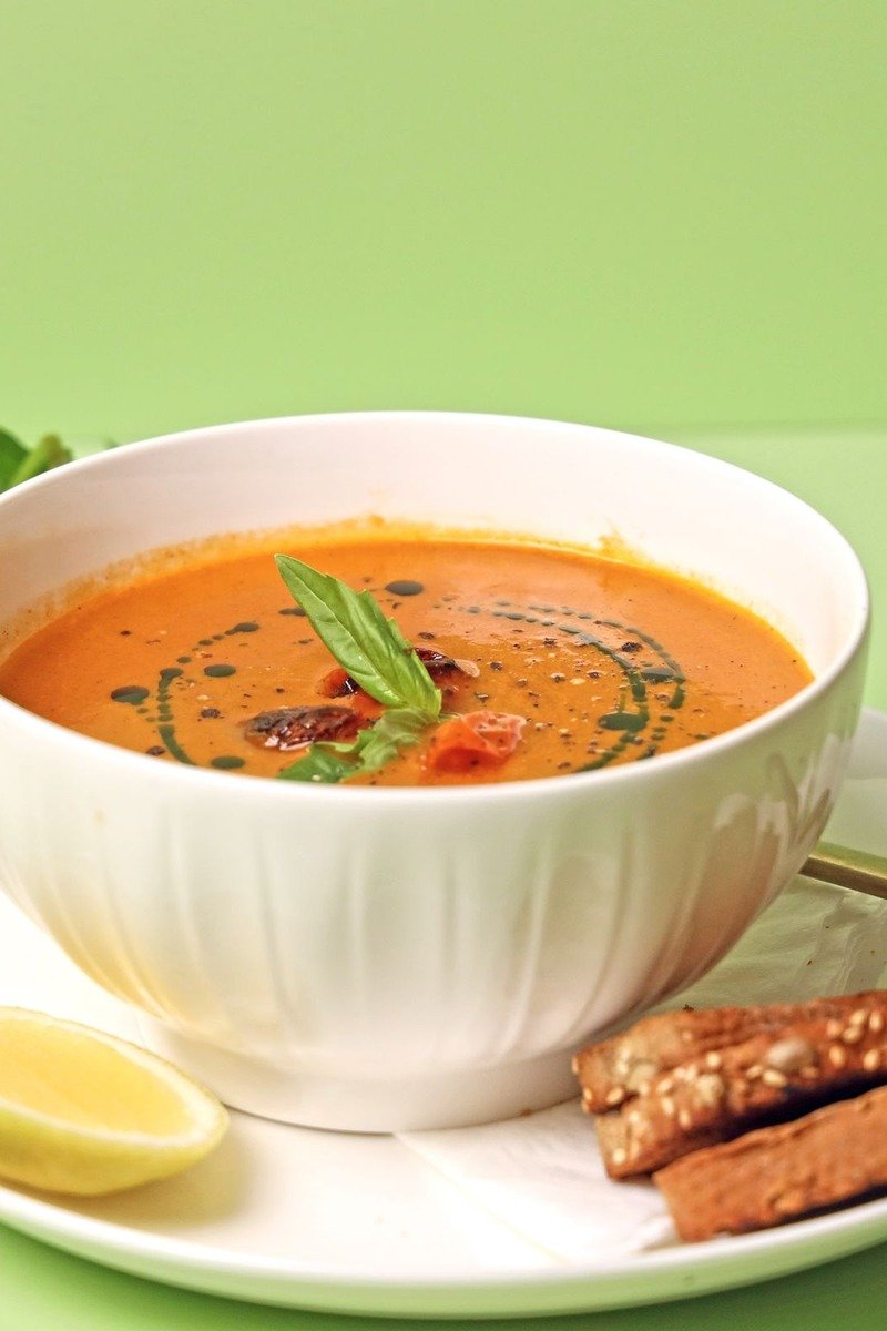 Creamy tomato soup in a bowl with basil