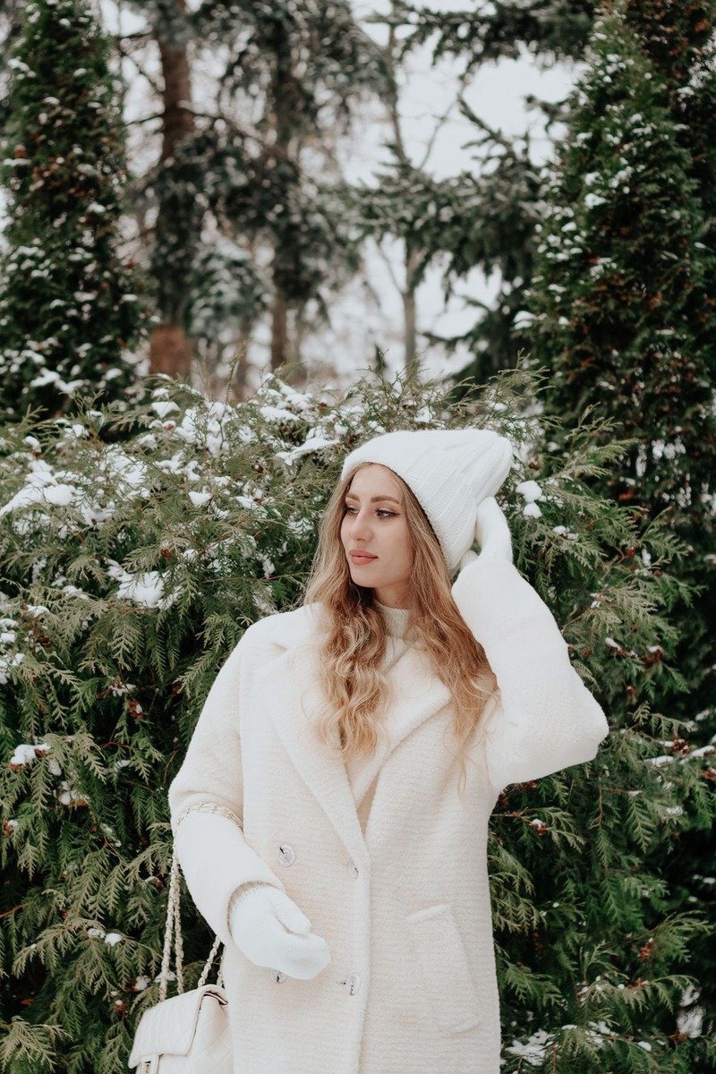 Woman in a winter white monochrome outfit in the snow
