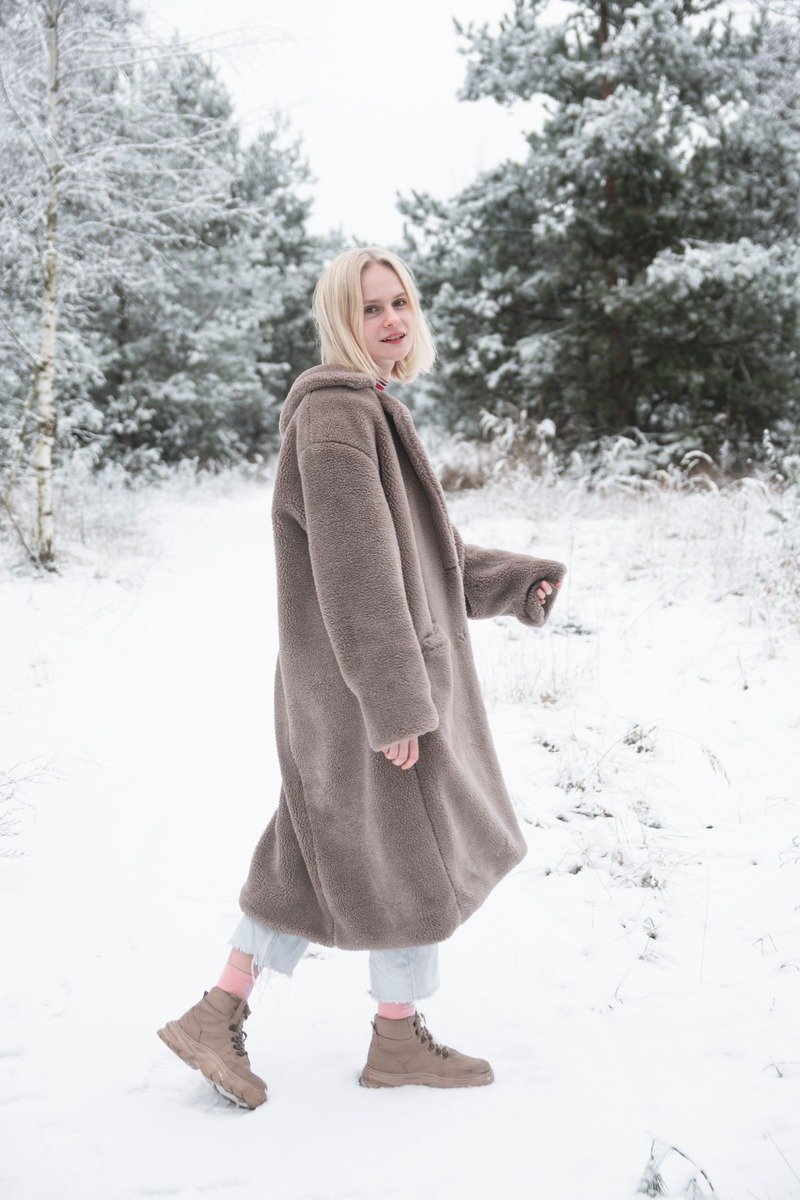 Woman over 40 in wool trousers with a parka and winter boots