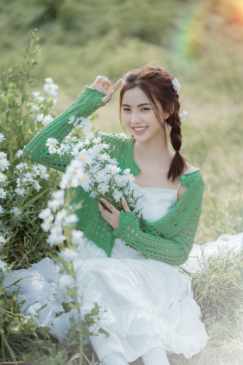 Woman in a green cardigan over a white dress