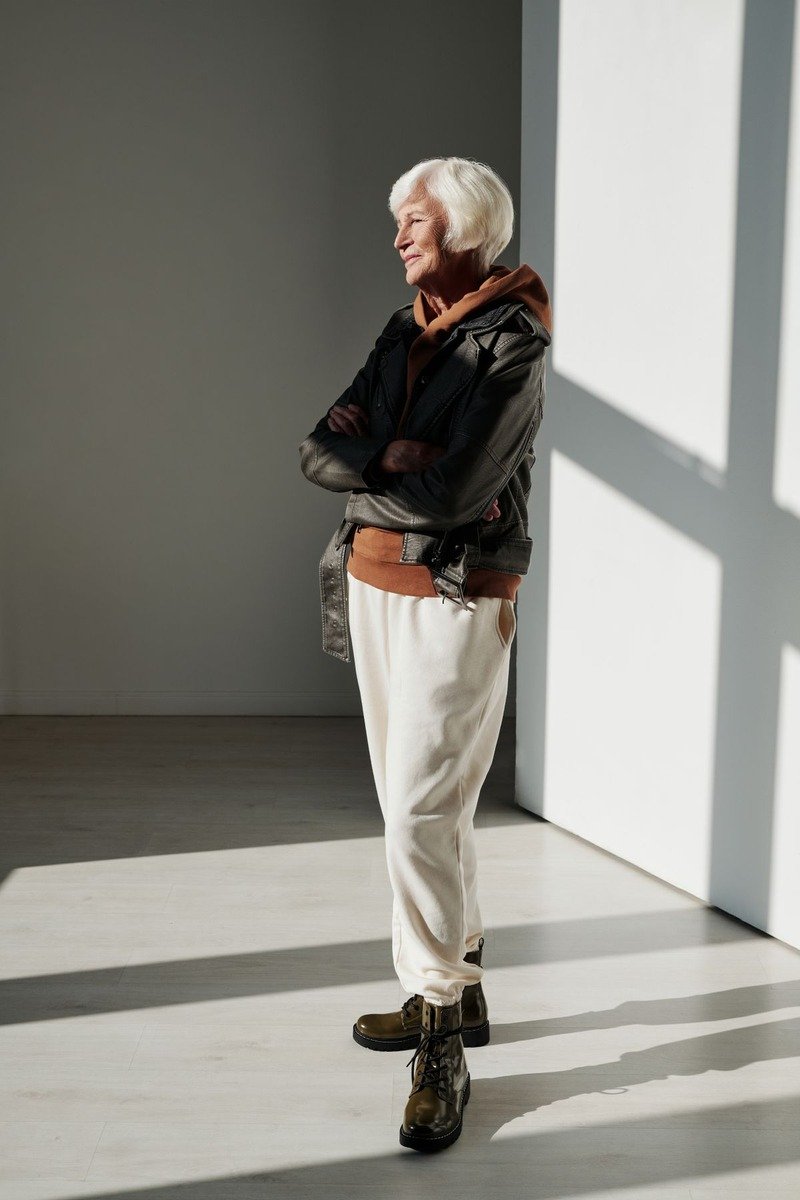 Woman in a leather jacket with a hoodie and boots in December