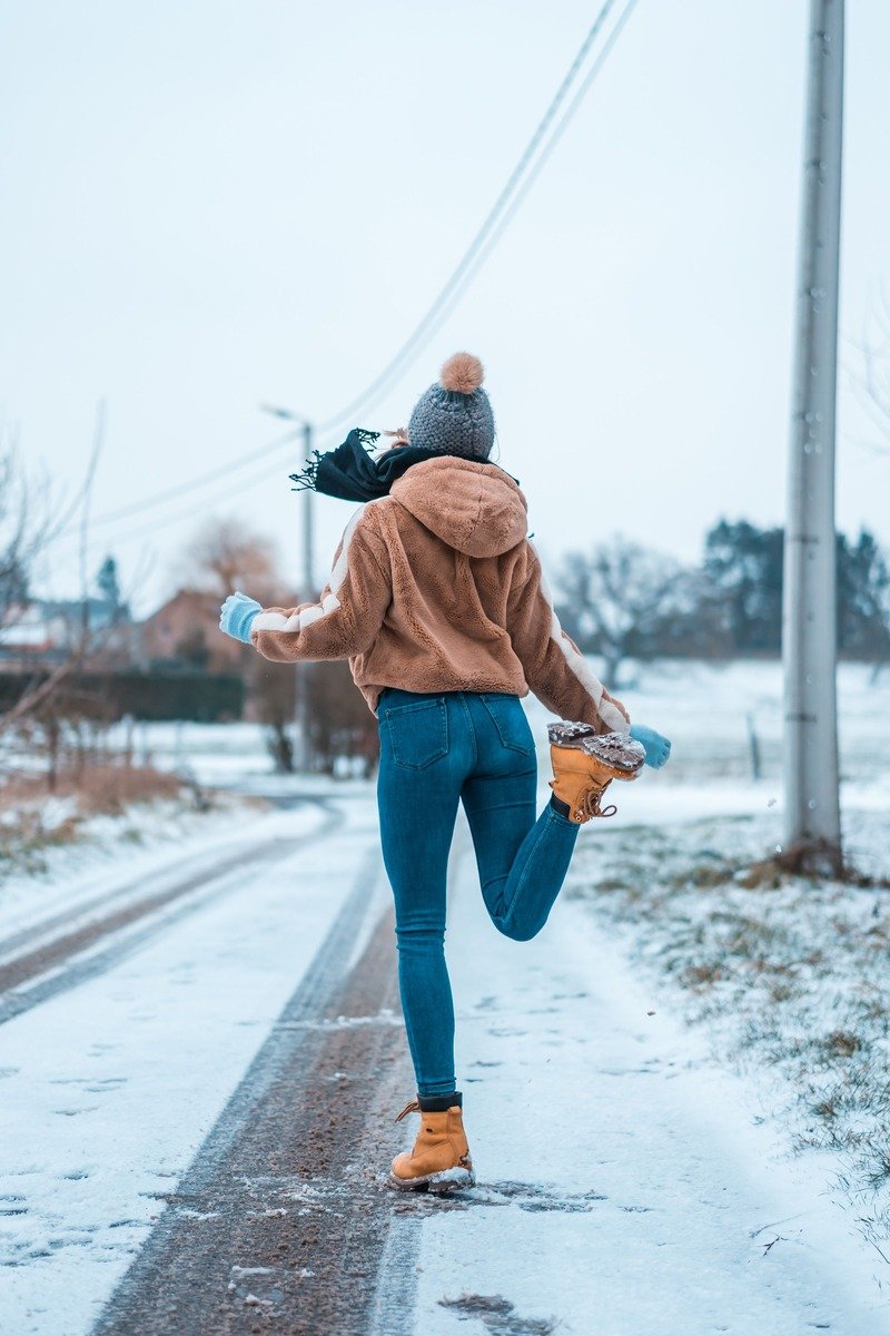 Woman over 40 in a fleece jacket with leggings and snow boots