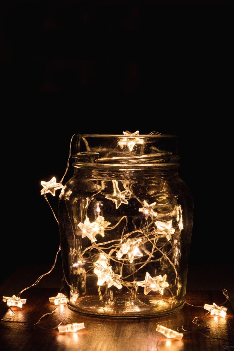 Fairy lights in a glass vase on a hearth