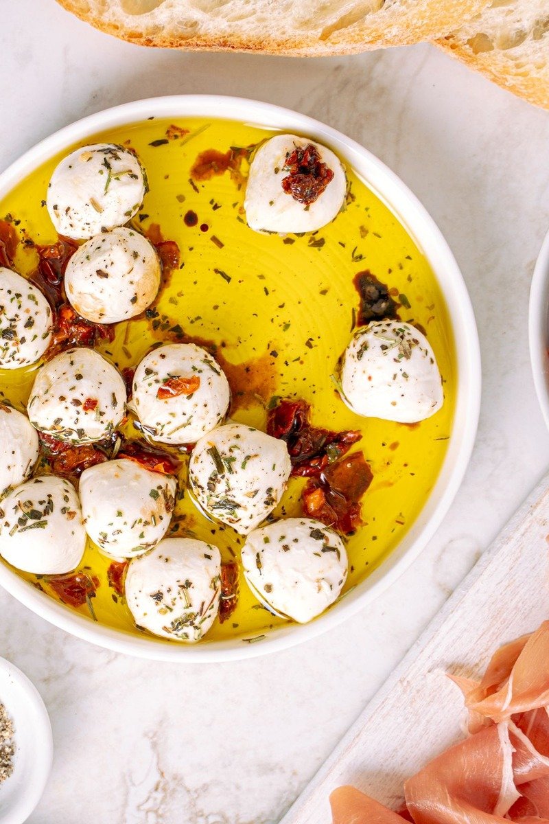 Marinated mozzarella balls with herbs in olive oil