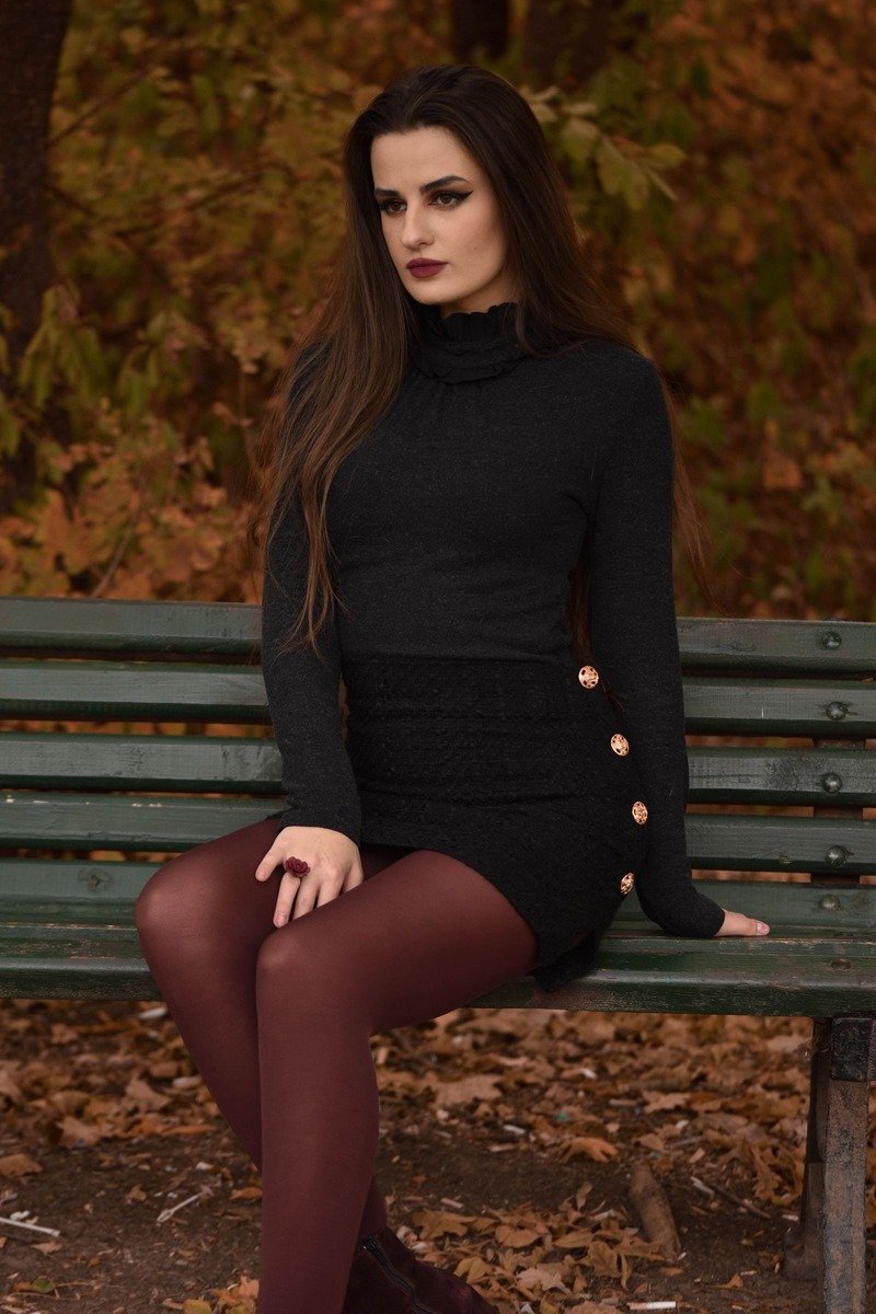 Woman in a black dress with burgundy tights