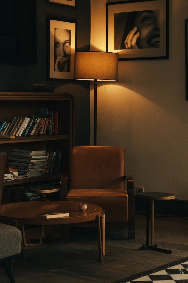 Beautifully styled reading nook with armchair, throw blanket, and small bookshelf
