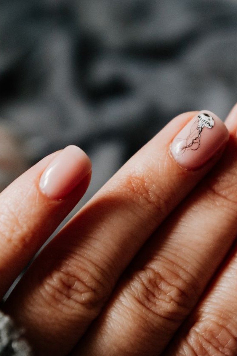 Sheer nude-pink nails with a jellyfish nail-art accent nail
