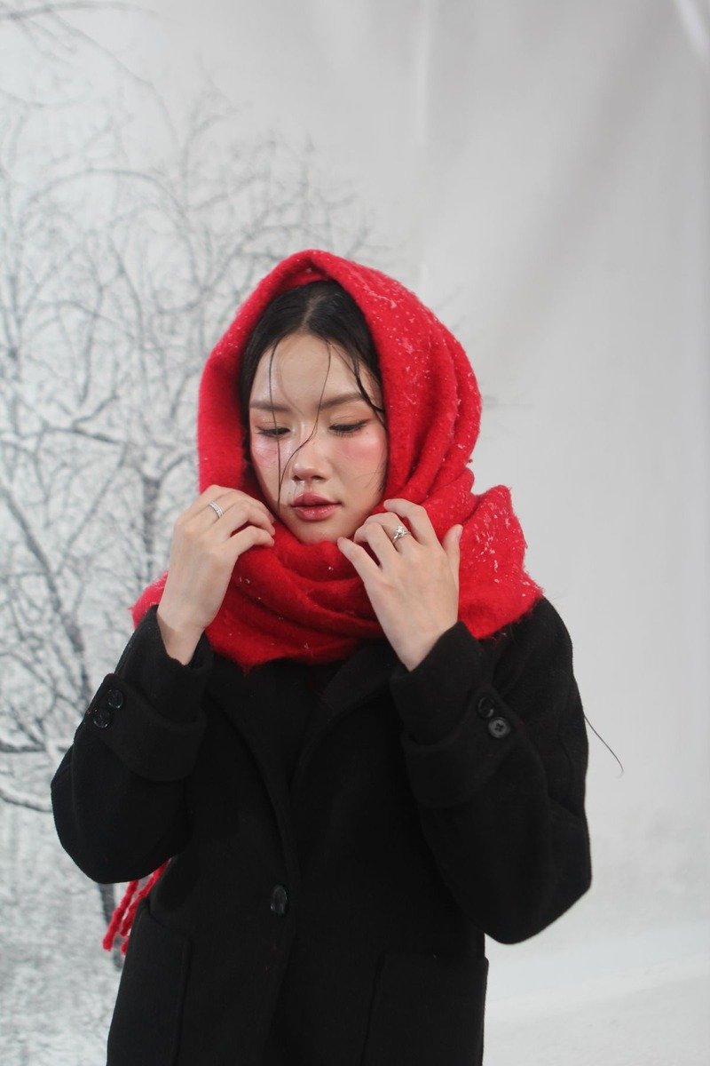 Woman in all black layers with a red scarf in winter