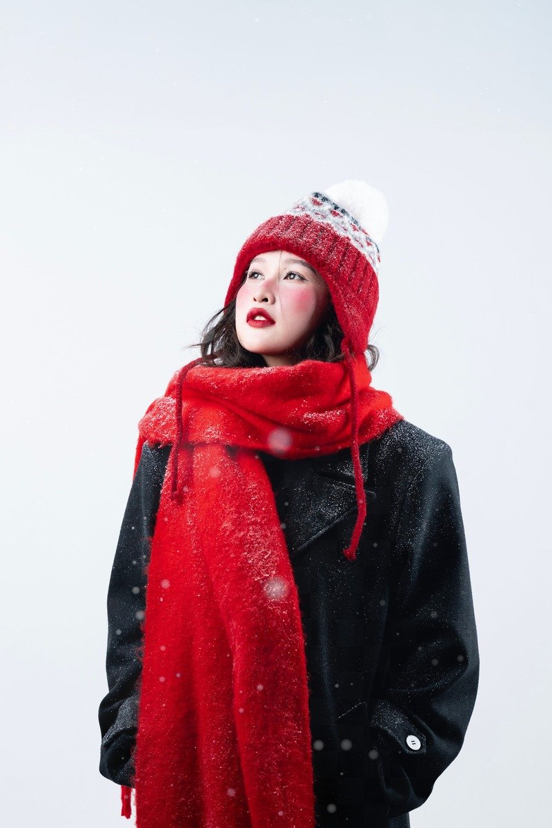 Woman over 40 in black winter layers with a bright red scarf