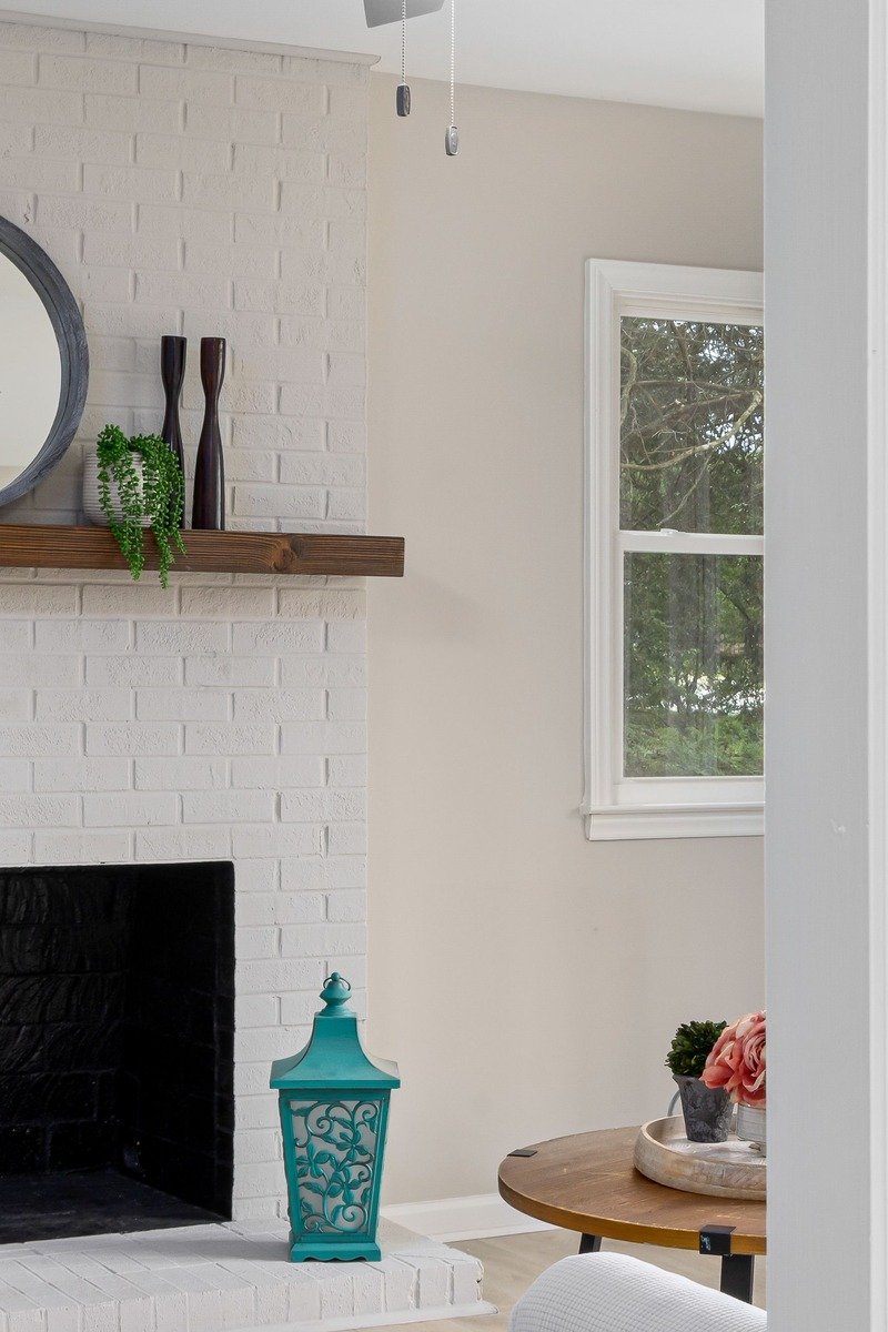 White painted brick fireplace with styled mantel