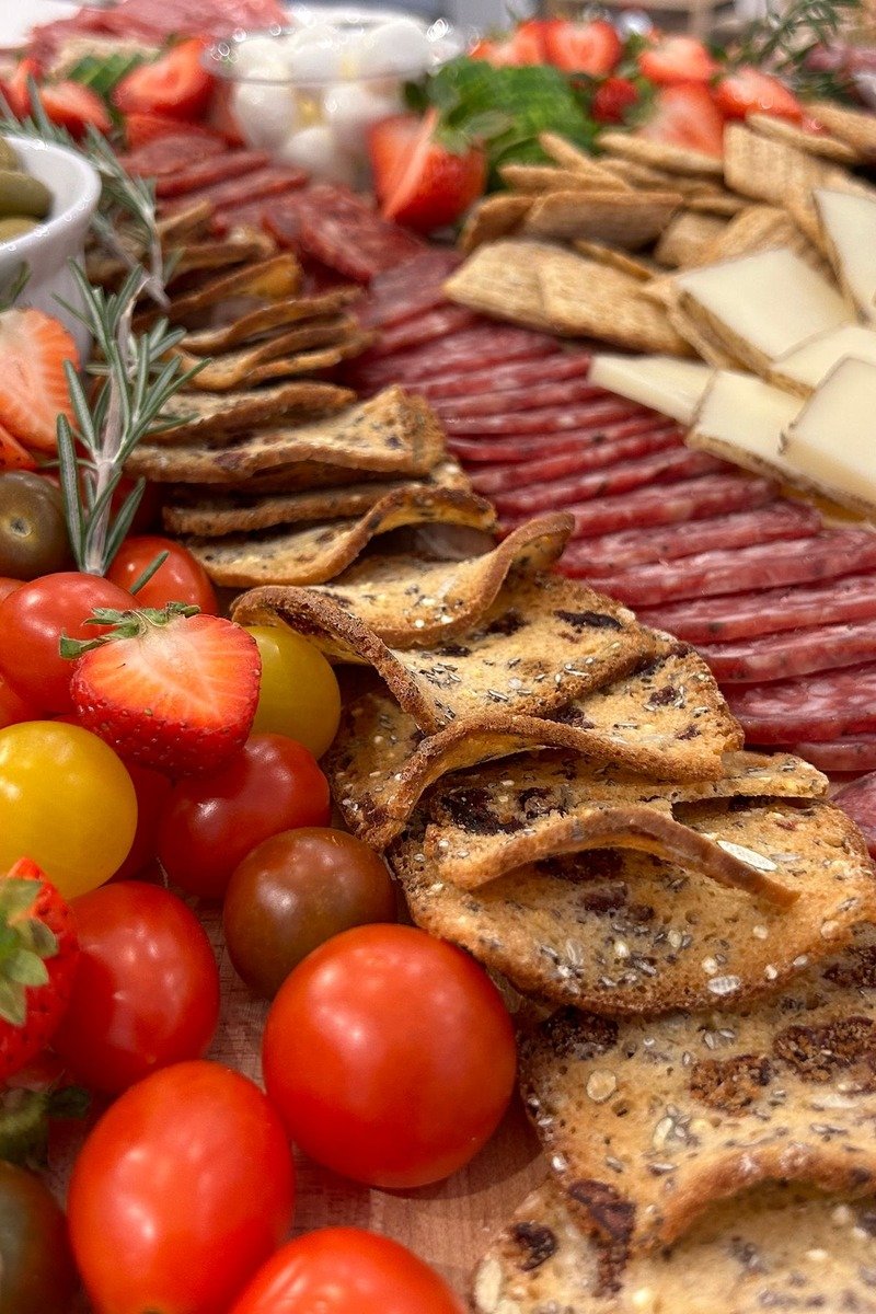 Charcuterie spread with salami cheese and crackers on a wooden board