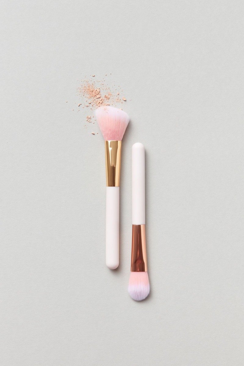 Fluffy brush applying dusty rose blush to cheekbones