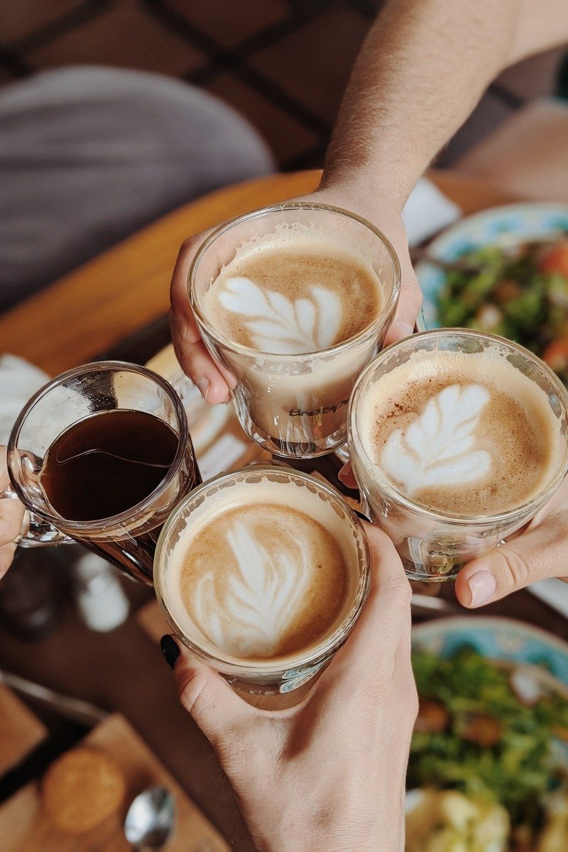 Group of friends toasting with mugs labeled with years of annual book club retreat tradition