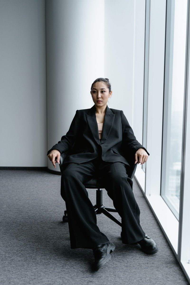 Woman in an all black winter workwear outfit at a modern office