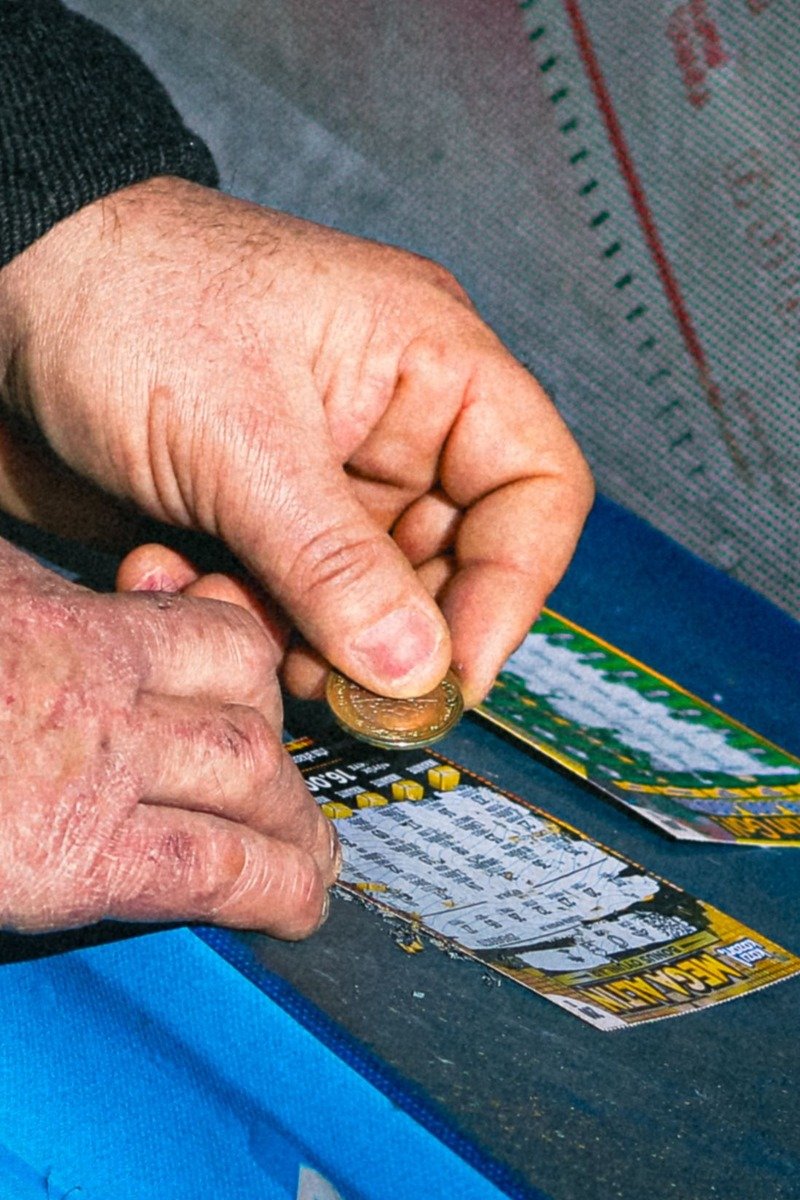 Hands scratching off lottery tickets with a coin