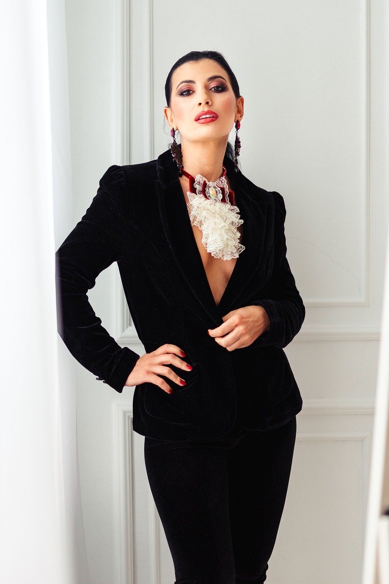 Woman in a velvet blazer and trousers at a winter office party