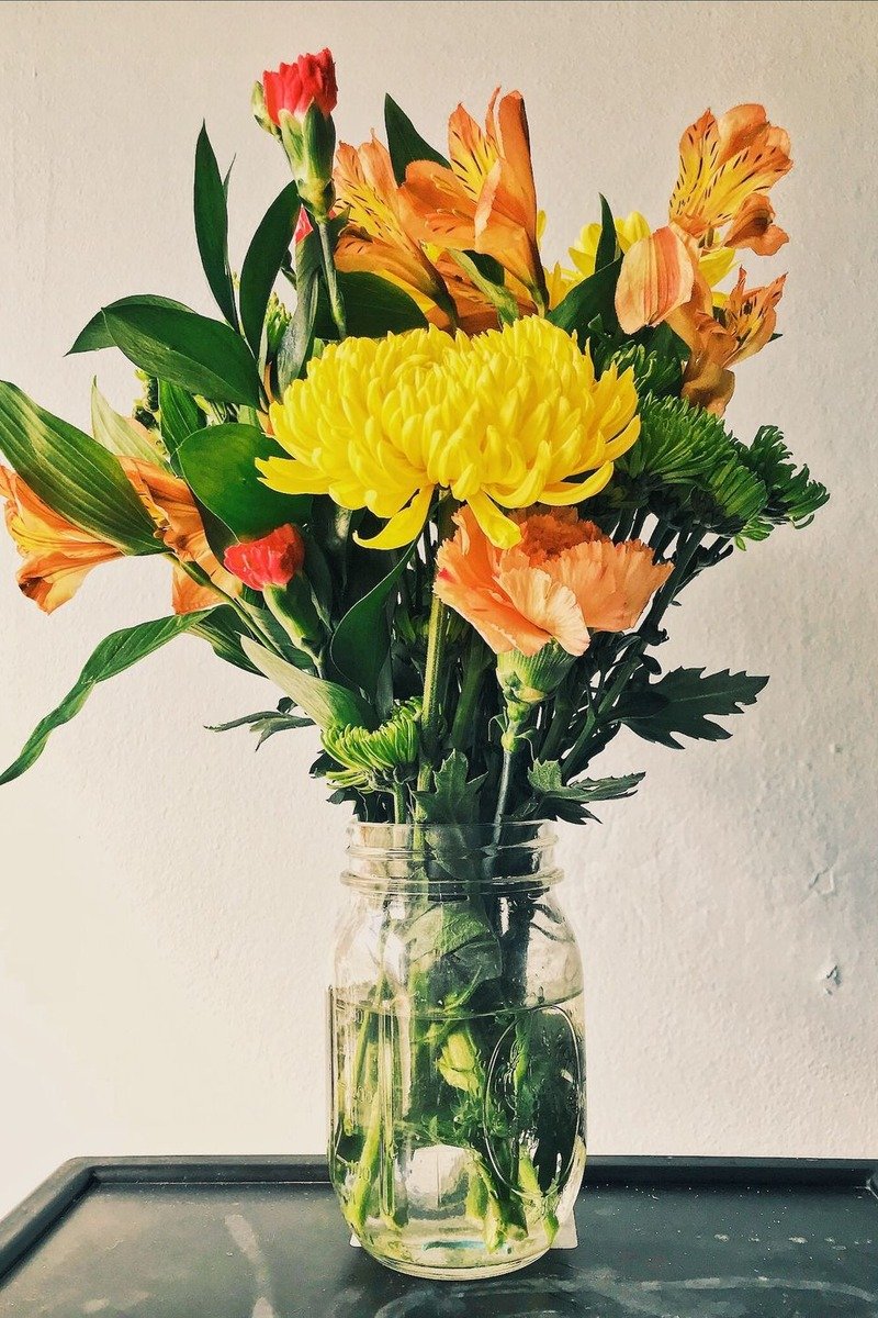 Painted mason jars with flowers as birthday centerpieces