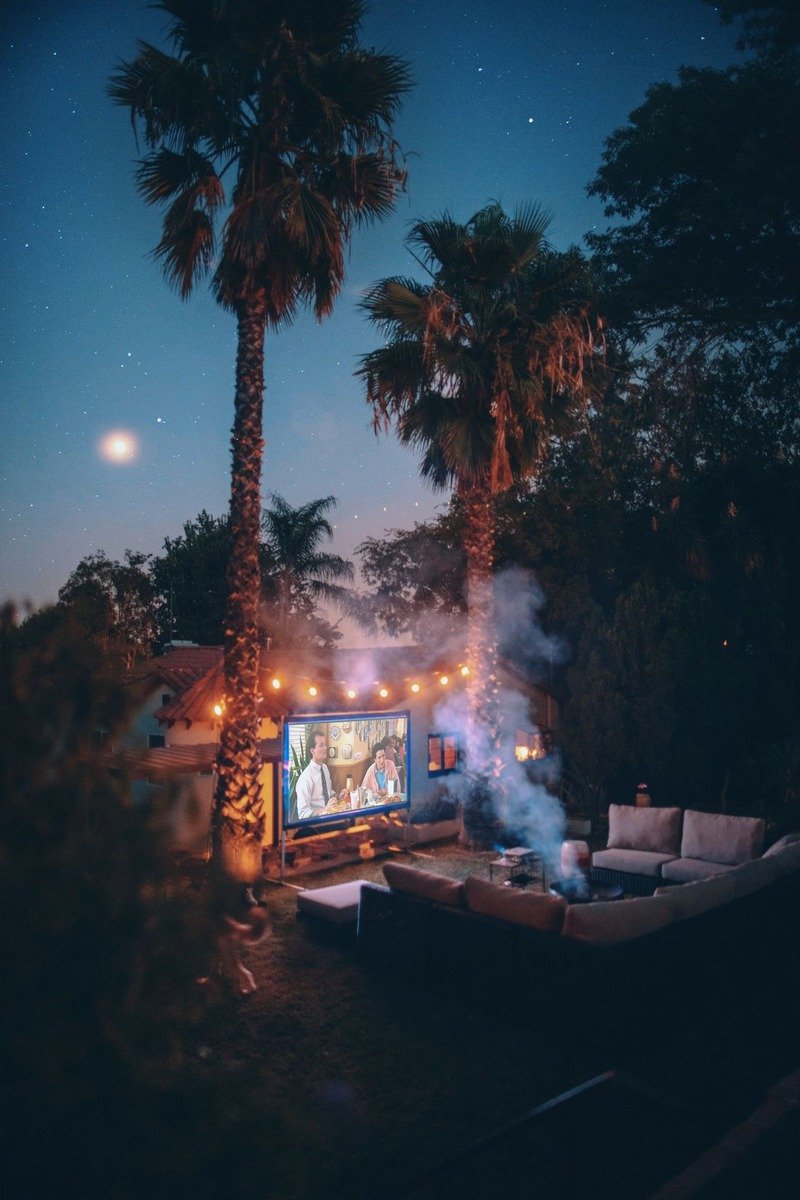 Backyard movie night setup with a screen and string lights